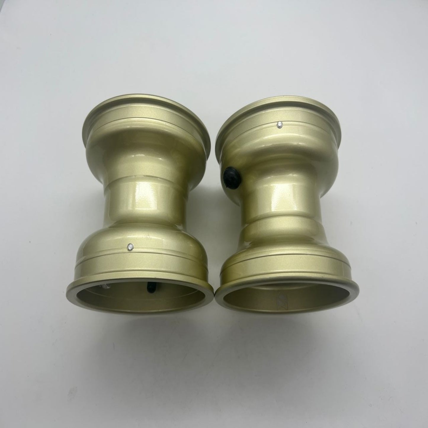Two gold-colored metal components 