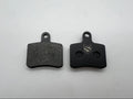 Two black brake pads on a white background