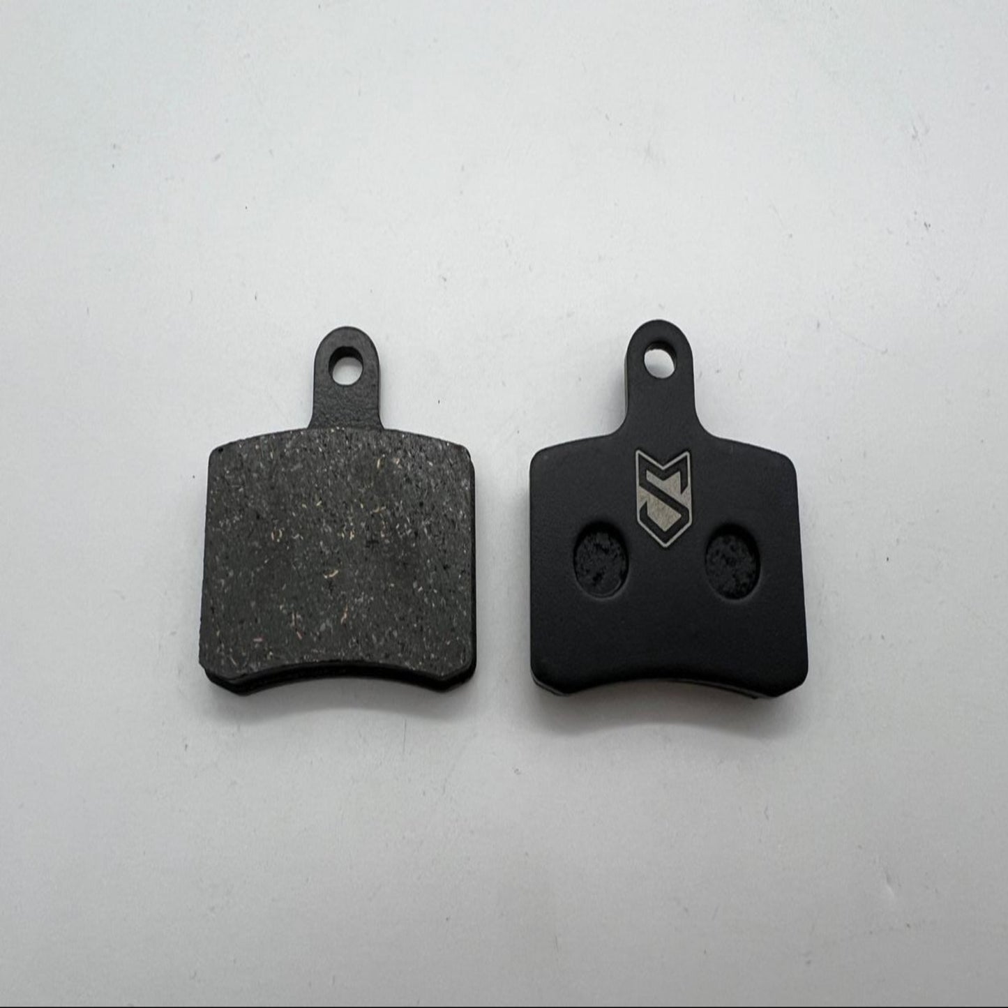 Two black brake pads on a white background